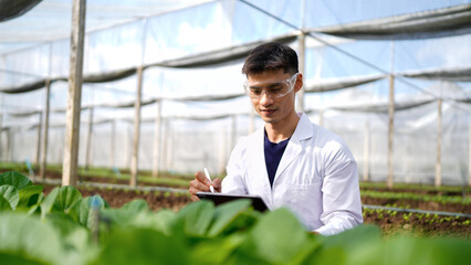 Agricultural developer handsome man trying different apps on tablet computer for advanced chemical...