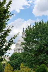 U.S. Capitol Dome Framed by Trees Under Cloudy Sky