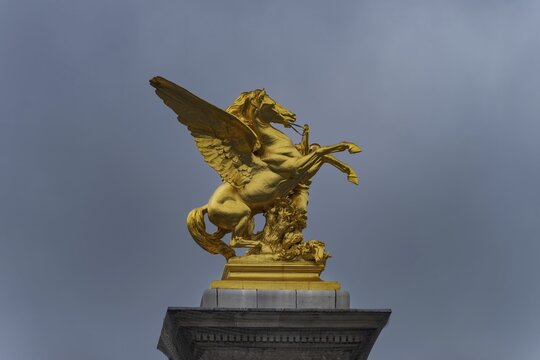 Column with the group of figures Fama of War on the Pont Alexandre III bridge over the Seine, Paris, France