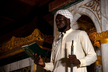 Muslim man praying by a window in a religious building.