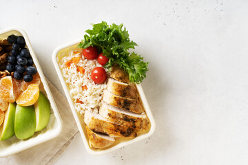 Lunch box with chicken, rice, vegetables, tomatoes, salad, fruits