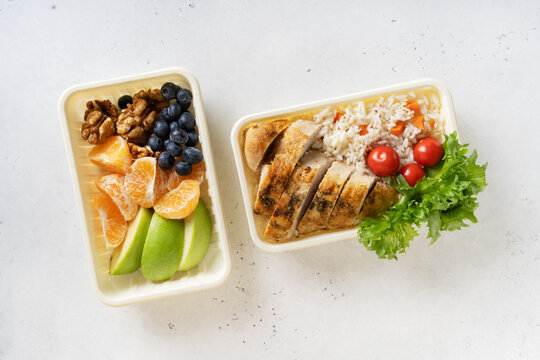 Lunch box with chicken, rice, vegetables, tomatoes, salad, fruits