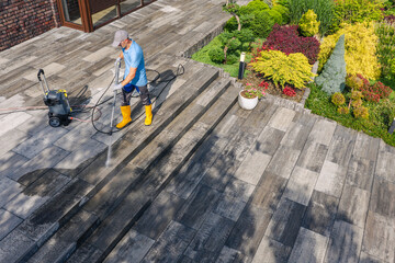 Worker Cleans Outdoor Surface With Pressure Washer Machine