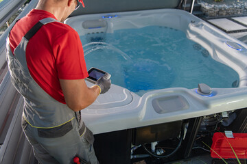 Worker Checks Hot Tub System With a Tablet in Backyard
