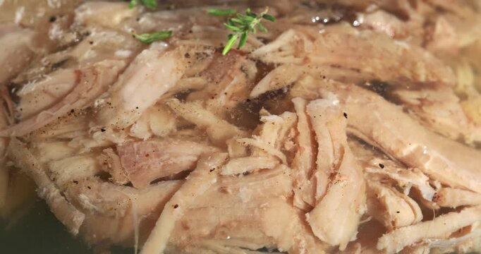 Aspic jellied meat on a dark background. Close-up footage on the rotating table.