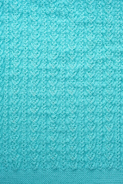 Fragment of blue-mint color handmade knitted sweater background. Woolen knitted pattern of threads texture for design. Detail of tracery woven knitwear texture. full frame. template for design