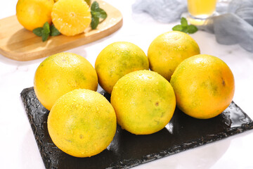 Fresh Yellow Oranges with Water Droplets on Slate Board
