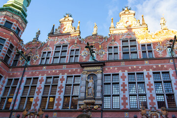 Fototapeta premium The building shows colorful walls with intricate designs and statues in Gdansk, Poland. The Great Armoury is a 17th-century former arsenal. The greatest example of Mannerist architecture in Gdansk.