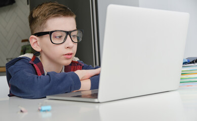 Boy doing homework on laptop