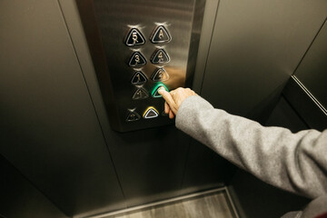 Senior hand pressing elevator button choosing floor
