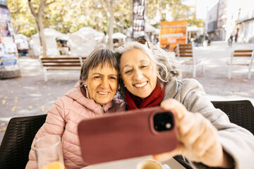 Senior women friends taking selfie outdoors