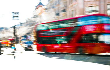 Postmodernism style, artistic motion of people crossing Oxford Circus junction at sunny day. British double decker buses at the background. London