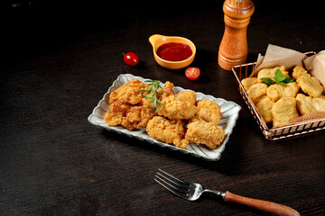 Golden Crispy Chicken Nuggets and Fried Food Plating on Dark Background for Restaurant Promotion