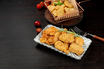 Crispy Fried Chicken Feast with Golden Nuggets on Dark Background