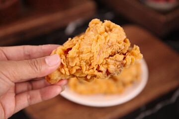 Crispy Fried Chicken Thigh in Hand - Golden Gourmet Fast Food Photography