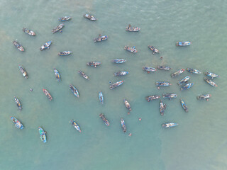 Aerial view of fishing boats scattered across the shimmering turquoise waters, their hulls casting faint shadows below, creating a mesmerizing dance of light and color.,Tam Tien, Quang Nam, Vietnam