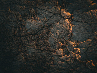 Aerial view of a rugged landscape, etched with deep fissures and bathed in the warm glow of sunlight, creating a stark contrast between light and shadow, Boston, Massachusetts, United States.