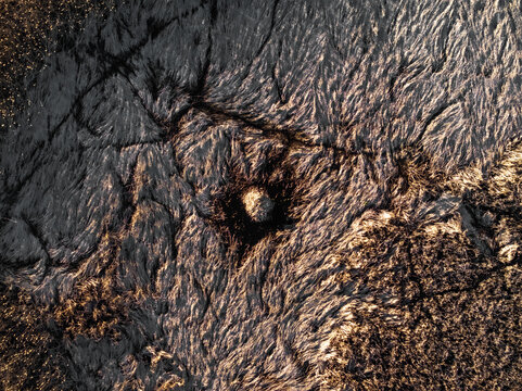 Aerial view of a textured, abstract landscape with contrasting dark and light tones suggesting a scorched earth, Boston, Massachusetts, United States.