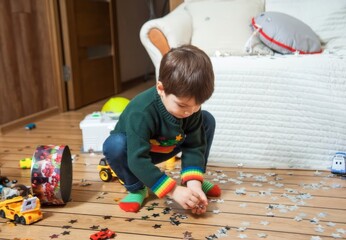 Child in Christmas Jumper Playing with Glitter Confetti on Floor. Holiday Morning Aftermath, new year