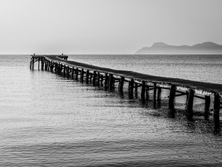 Wooden pier in Alcudia, Mallorca. Pier in Mallorca an early morning. Black and white photo. The image was taken in June 2025.