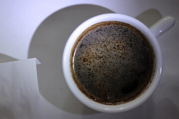 A coffee cup with a piece of paper.