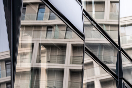 Modern architecture glass facade with geometric reflection pattern on urban building creating abstract dynamic city background with contemporary style