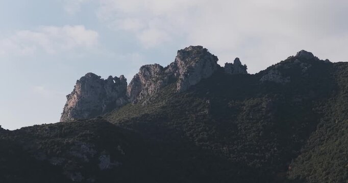 Aerial view of the rugged, dark mountains of Erchie, a scene punctuated by rocky outcrops and lush greenery, Amalfi Coast, Erchie, Amalfi Coast, Italy.