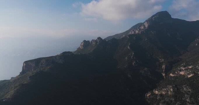 Aerial view of the rugged mountains contrasting with the soft blue sky, showing the natural beauty of the landscape, Erchie, Amalfi Coast, Italy.