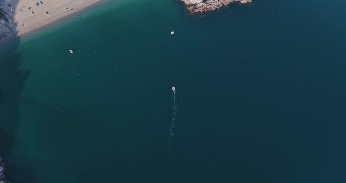 Aerial view of the dark blue sea contrasts with the light sand beach of Erchie, with boats scattered on the water, Erchie, Amalfi Coast, Italy.