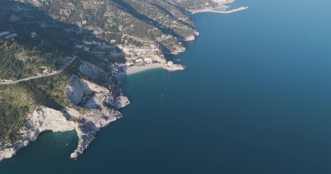 Aerial view of the beach contrasting with the rocky cliffs and deep blue sea, creating a stunning coastal vista, Erchie, Amalfi Coast, Italy.