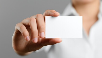 Fototapeta premium Woman Holding A Business Card In Her Hand Against A White Background, Isolated With A Clipping Path For Easy Removal.