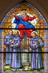 Wandcirkels plexiglas Jezus Christus RAVELLO, ITALY - OCTOBER 7, 2025: The St. Francis of Assisi with the Virgin Mary and brothers in the stained glasss of  the church Chiesa di San Francesco by Pietro Musto (1988).  © Renáta Sedmáková