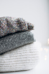 Neutral folded sweaters with soft bokeh in warm minimalist style.