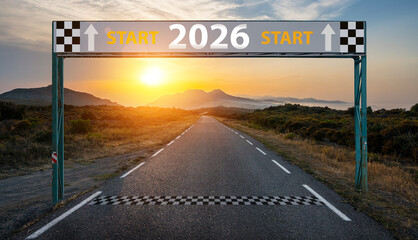 New year 2026 or start straight and beginning concept. Man ride on bike and the number 2026 start written on the road at sunset with lens flare. Concept of challenge or career path, business strategy.