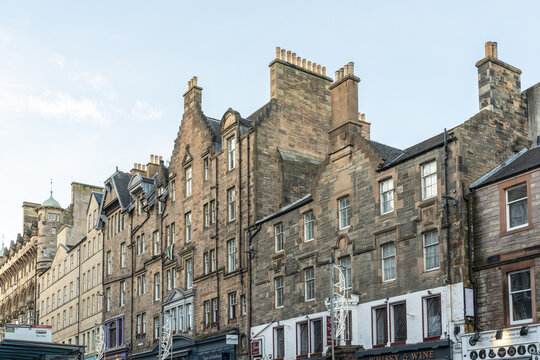 View of aged stone buildings stand shoulder-to-shoulder under a pale sky, their varied heights and textures creating a striking urban skyline, Edinburgh, Scotland, United Kingdom.