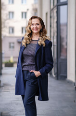 Fototapeta premium Confident middle aged business woman, confident lady manager, mature female professional executive, corporate leader wearing suit standing in office arms crossed looking at camera. Vertical portrait.