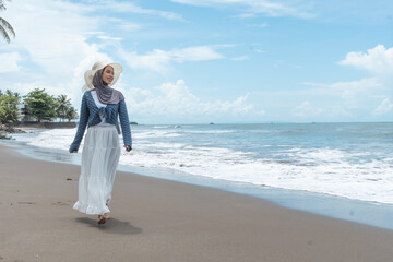 A young woman enjoys a holiday on a beautiful beach in Anyer, Indonesia.
