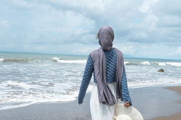 A young woman enjoys a holiday on a beautiful beach in Anyer, Indonesia.