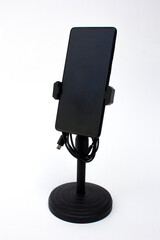 Smartphone or mobile phone in the stand, isolated on white background. Modern Mockup of a mobile phone with a dark display.