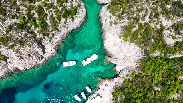Aerial drone cinematic video of tropical exotic seascape ideal for snorkeling with sea caves and white limestone rocks resembling a blue lagoon