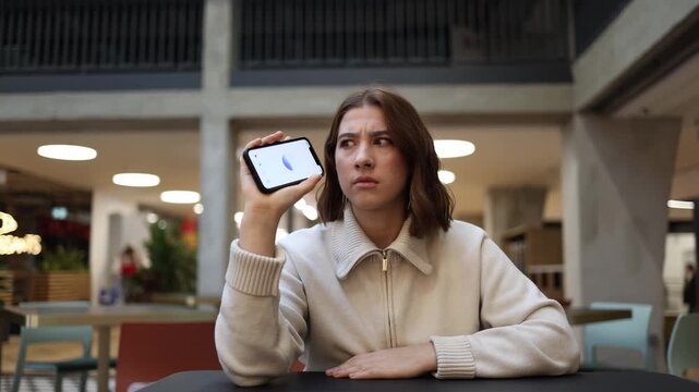 ChatGPT confuses young woman as she listens to strange response holding phone and freezing in uncertainty during awkward conversation and emotional hesitation