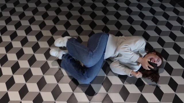ChatGPT triggers uncontrollable laughter as young woman falls on the floor laughing hard after a funny response during playful voice chat interaction