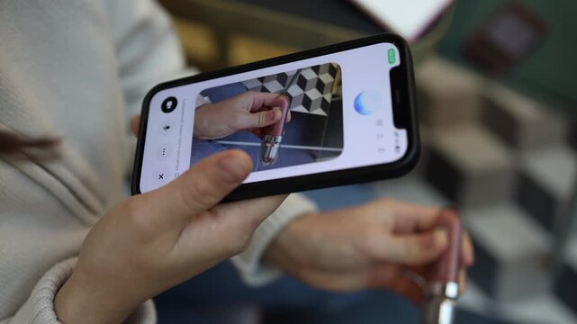 ChatGPT consults woman about cosmetic product as she shows new lip gloss on smartphone and asks for beauty advice usage tips and makeup recommendations