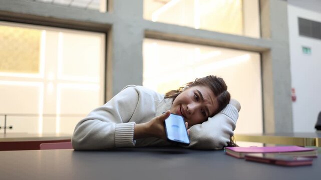ChatGPT listens to tired student during nonstop voice monologue as she rests on table using digital assistant as late support after study and work indoors