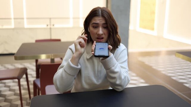 ChatGPT faces direct complaint as young woman speaks sharply into smartphone tense face frustration distrust and dissatisfaction during emotional indoor conversation