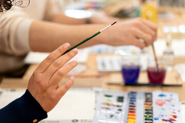 Hand holding paintbrush during drawing workshop © Alfonso Soler