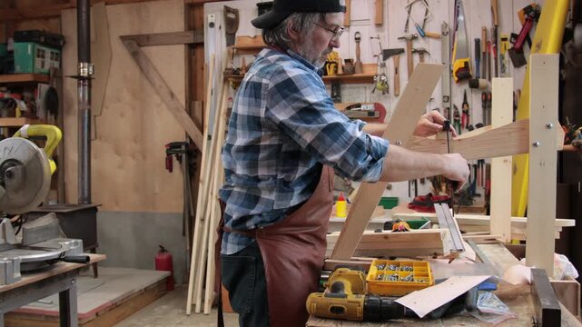 A carpenter assembles an Adirondack chair