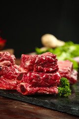 Fresh Raw Beef Cuts with Garlic and Parsley on Slate