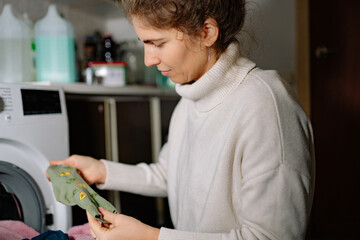 Woman sorting clothes in laundry room during household chores on a regular day