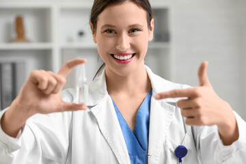 Female ophthalmologist pointing at eye drops in clinic